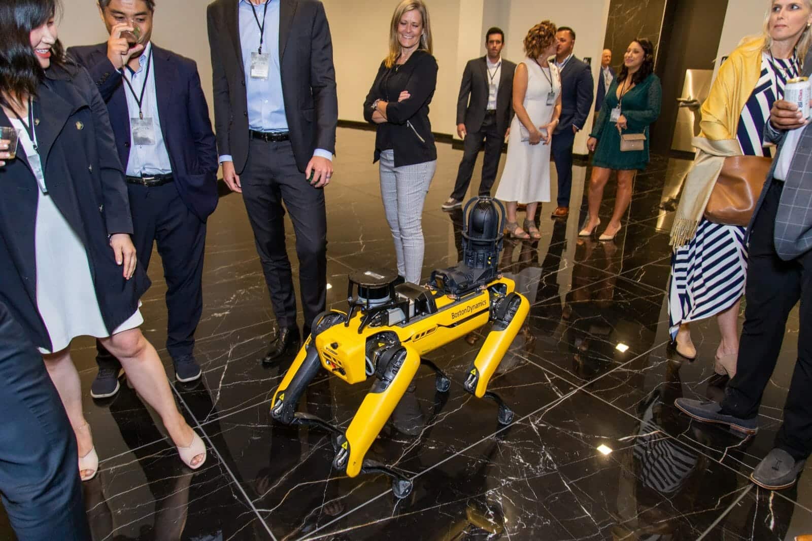 A group of people at an event surrounding a BostonDynamics robodog which is used for security at Novva's data centers.