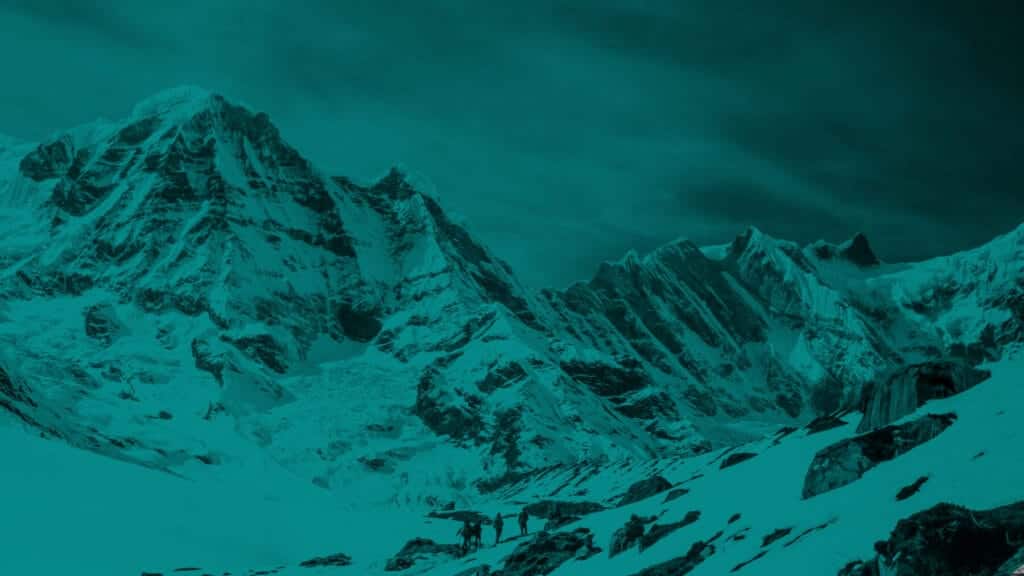 A small group of hikers amongst snowy mountain peaks with a blue overlay