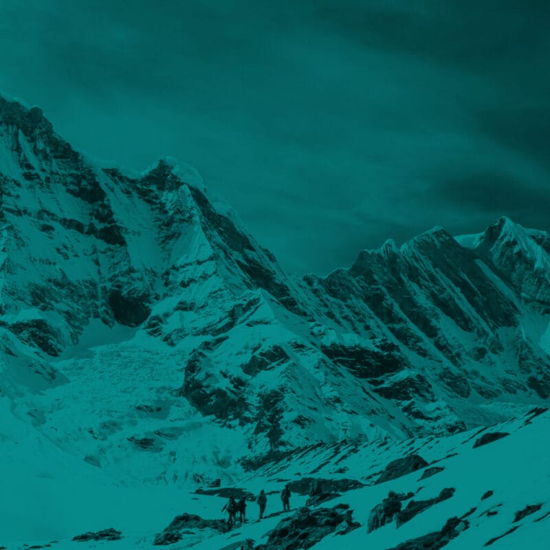 A small group of hikers amongst snowy mountain peaks with a blue overlay